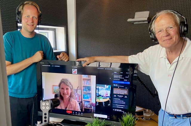 Drie mensen in een podcastopnamestudio