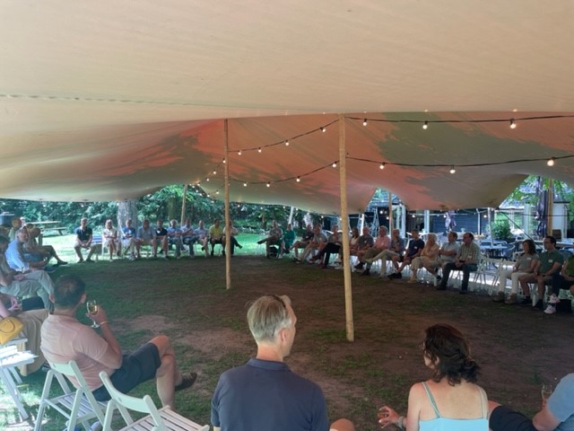 Een groep FNL leden die in een cirkel onder een grote tent zit