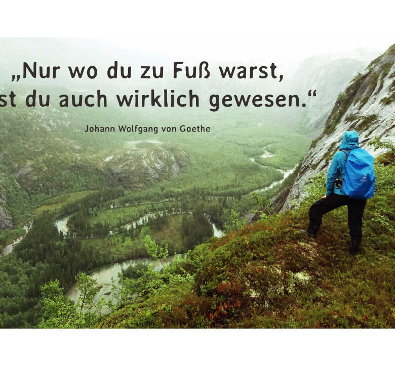 Persoon kijkt uit over een vallei met het Goethe-citaat 'Nur wo du zu Fuß warst, bist du auch wirklich gewesen.'